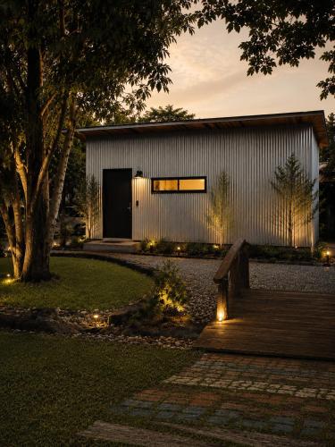 a house with a bench and lights in the yard at Hidden hush hideaway in Ban Mo