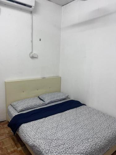 a bedroom with a bed in a white room at NR Guest House in Kangar