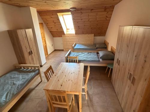 a room with two beds and a table and chairs at Vila Stella Vita in Chrbonín