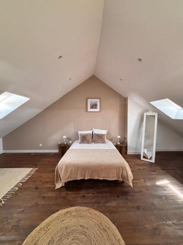 a bedroom with a large bed in an attic at La maison de mamy in Bray-Dunes