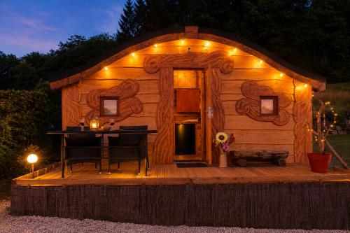 a log cabin with a table and lights on it at Les cabanes féeriques d'Amoncourt in Amoncourt