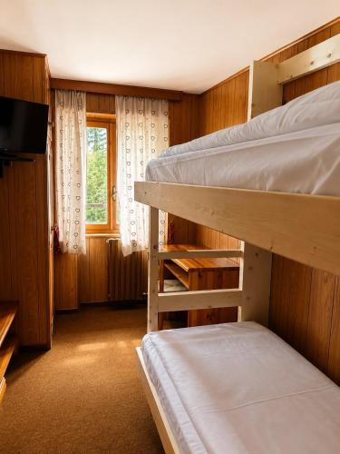 a room with two bunk beds and a television at Locanda del Lysjoch in Gressoney-la-Trinité