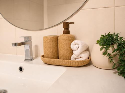 a bathroom with a sink with towels and a mirror at 2BR Retro Luxe Family Hideaway in Gold Coast