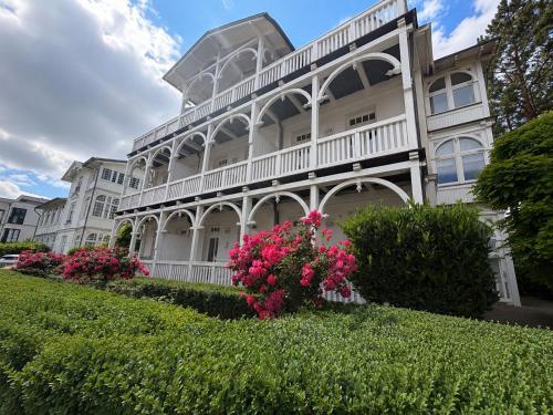 a white house with pink flowers in front of it at Villa Jugendglück in Binz