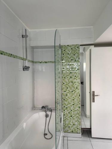 a bathroom with a tub and a glass shower at Ground-Floor Apartment With private Garden in Étampes