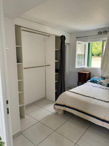 a bedroom with a bed and a window and shelves at Ground-Floor Apartment With private Garden in Étampes
