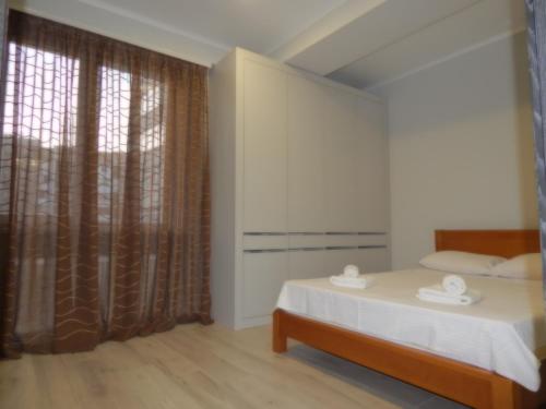 a bedroom with a bed and a large window at Mircea cel Batrin apartament in Chişinău