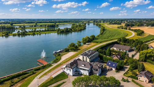 an aerial view of a house next to a river at Hotel Hoogeerd by Flow Niftrik - Nijmegen in Niftrik