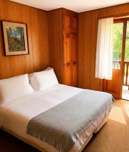 a bedroom with a large white bed with a window at Locanda del Lysjoch in Gressoney-la-Trinité
