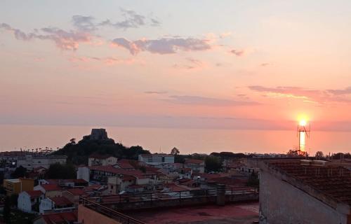 a view of a city at sunset with a lighthouse at Marina Panoramic Sea View in Scalea