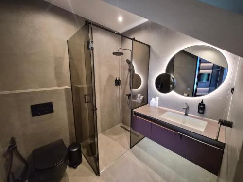 a bathroom with a shower and a sink and a mirror at Monte SPA Villas in Banya