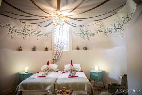 a bedroom with two beds and two candles on the wall at Château de Najade in Sainte-Sévère-sur-Indre