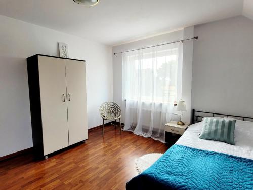 a bedroom with a bed and a dresser and a window at Apartament Nad Lodziarnią in Wydminy