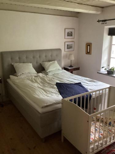 a white bed with a crib in a bedroom at Erikslund in Hurva