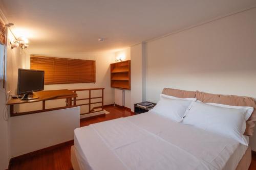 a bedroom with a bed and a desk with a television at Jenny's Appartment in Faraí