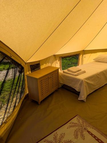a tent with a bed and a table in it at Wild Cretan West in Drakiana