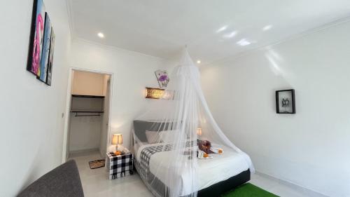 a bedroom with a bed with a mosquito net at The Winaposa in Munduk