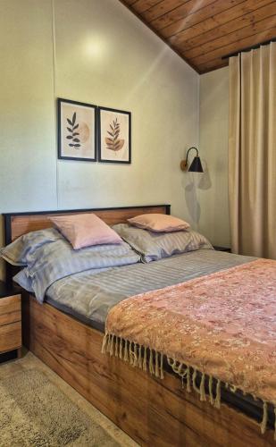 a bed in a bedroom with two posters on the wall at Cichy Brzeg Mazurski in Popowo Salęckie