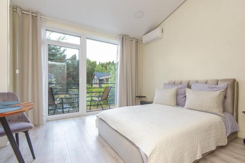 a bedroom with a bed and a large window at 2rest in Palanga