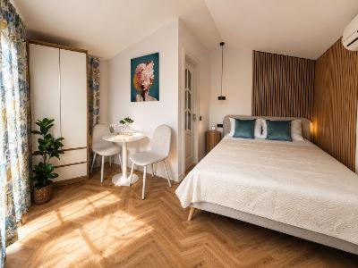 a bedroom with a bed and a table with chairs at Vila La Famiglia in Eforie Nord