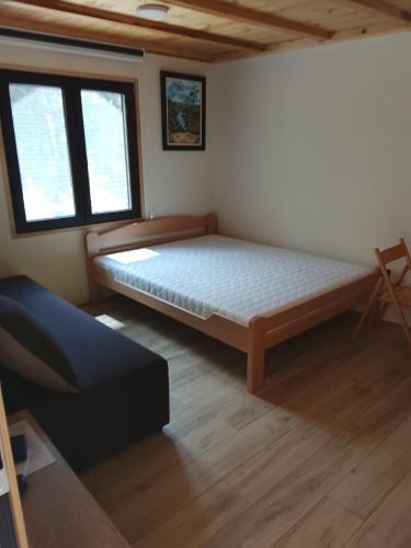 a bedroom with a bed and two windows at Air Zaovine in Bajina Bašta