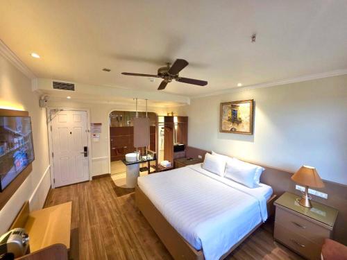 a bedroom with a large bed with a ceiling fan at Tulip Hotel 2 in Da Lat