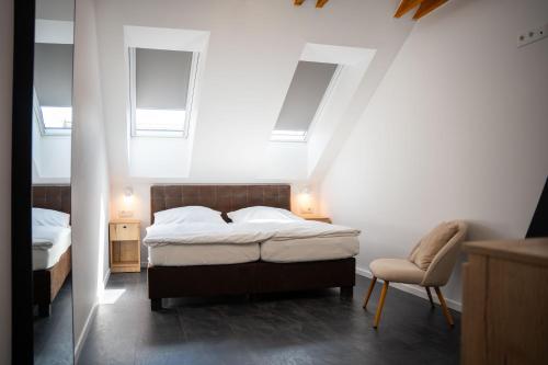 a bedroom with a bed and a chair and skylights at CASTLE apartments Premium - City Center in Spišské Podhradie