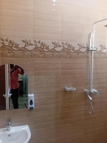 a person taking a picture in a bathroom mirror at Nelca Executive Lodge in Mwanza