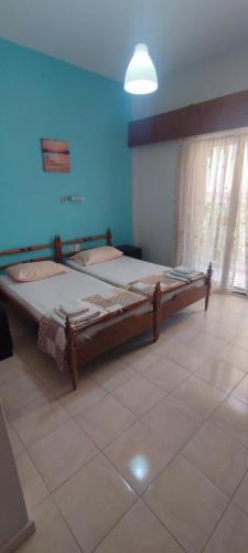 a bedroom with two beds and a blue wall at Villa Sia in Dassia