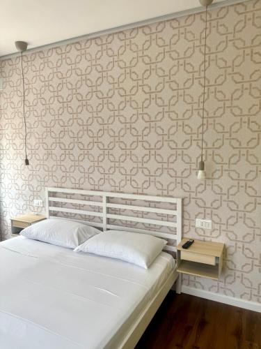 a bedroom with a white bed and a wall at Arcimboldo 2 apartment in San Canzian dʼlsonzo