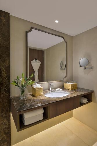 a bathroom with a sink and a large mirror at Boulevard9, Nadiad - IHCL SeleQtions in Nadiād