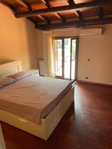 a bedroom with a bed and a sliding glass door at la Dimora del centro di zafferana in Zafferana Etnea