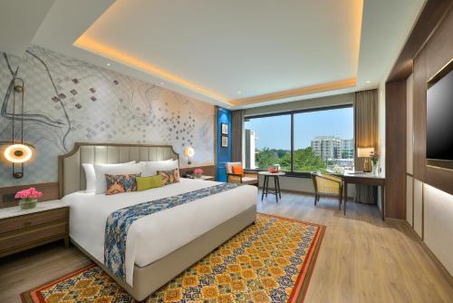a hotel room with a large bed and a desk at Boulevard9, Nadiad - IHCL SeleQtions in Nadiād