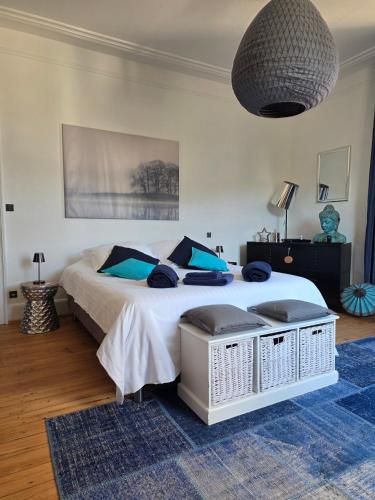 a bedroom with a large white bed with blue pillows at Villa Amarinis in Saint-Amarin