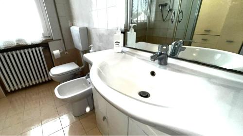 a white bathroom with a sink and a toilet at Appartamento ROMANA in Lugo