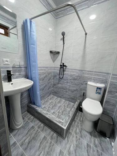 a bathroom with a shower and a toilet and a sink at Sobirjon Guest House in Khiva
