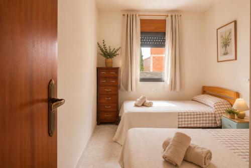 a small bedroom with two beds and a window at Casa Bon Matí in L'Ampolla