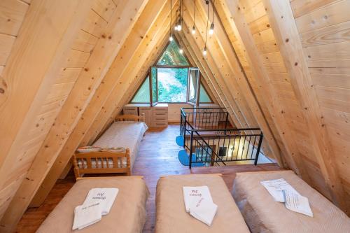 a room with four beds in a wooden cabin at Brvnara Iva Kolašin Crna Gora in Selišta