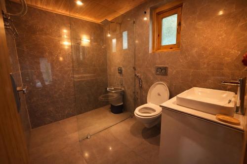 a bathroom with a toilet and a shower and a sink at River Retreat Resort in Pahalgām