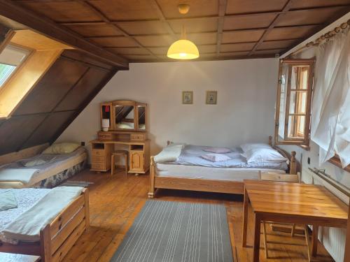 a bedroom with two beds and a desk and a table at Agroturystyka Pod Jesionami in Lądek-Zdrój