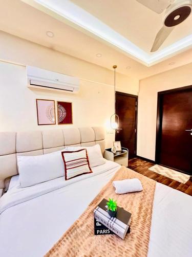 a bedroom with a large white bed with a table at LMY Boutique Hotel Serviced Apartments Blue Area Islamabad in Islamabad