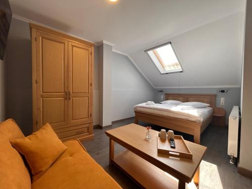 a bedroom with a bed and a couch and a table at La SOFIIA in Săpânța