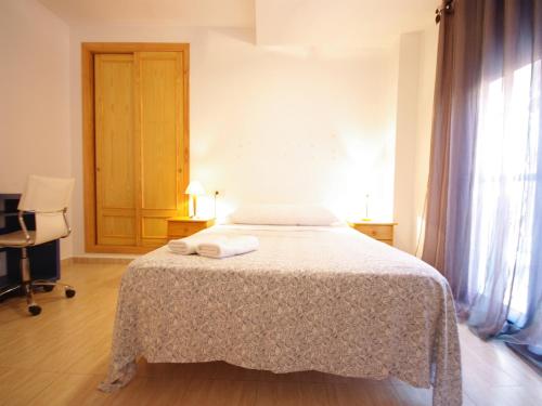1 dormitorio con 1 cama con 2 toallas en Livingtarifa Apartamento Blue I, en Tarifa
