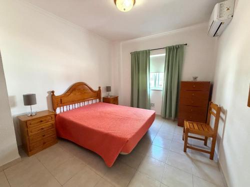 a bedroom with a bed and a dresser and a window at Casa Nau B in Armação de Pêra