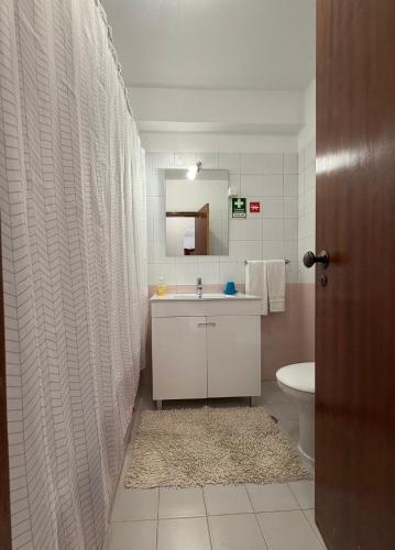 a bathroom with a sink and a toilet and a mirror at Casa Nau B in Armação de Pêra