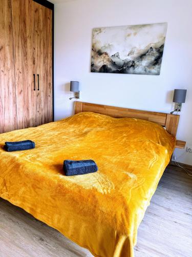 a bed with two blue pillows on top of it at Apartmán Valašský Eden in Horní Bečva