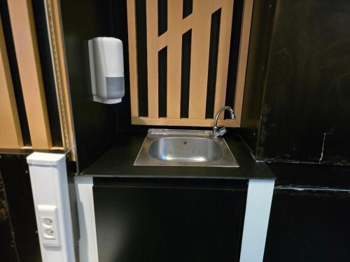 a bathroom with a sink and a soap dispenser at kyoto b&b in Ostend