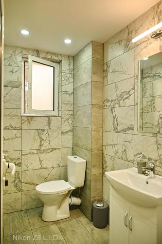 a bathroom with a toilet and a sink at Zlatna Ribka in Chernomorets