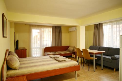 a room with a bed and a couch and a table at Zlatna Ribka in Chernomorets