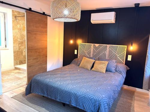 a bedroom with a bed with a blue comforter at Cottage cosy avec terrasse 5pers proche Etretat in Bolbec